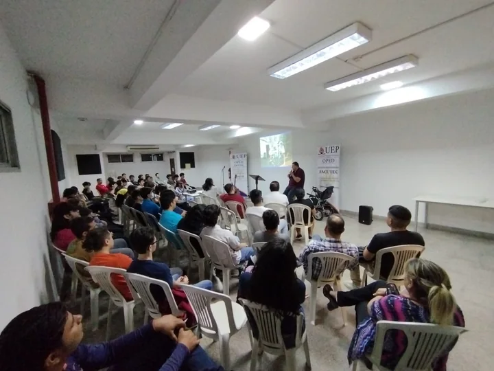 Estudiantes sentados escuchando una charla en el salón auditorio